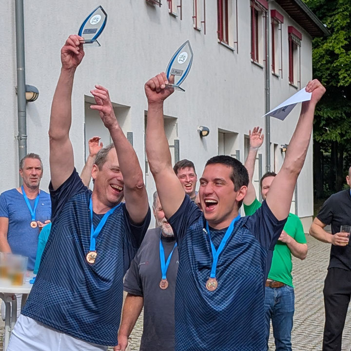 720x720_Prellball-Voelker_Blog Zwei Männer halten einen Pokal hoch und jubeln