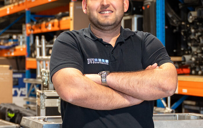 Ivo Fernandes steht vor einem Regel mit Equipment
