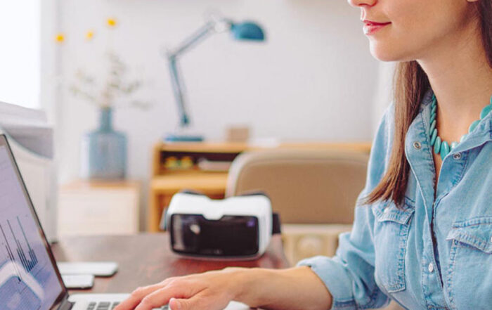 Frau sitzt am Laptop am Schreibtisch
